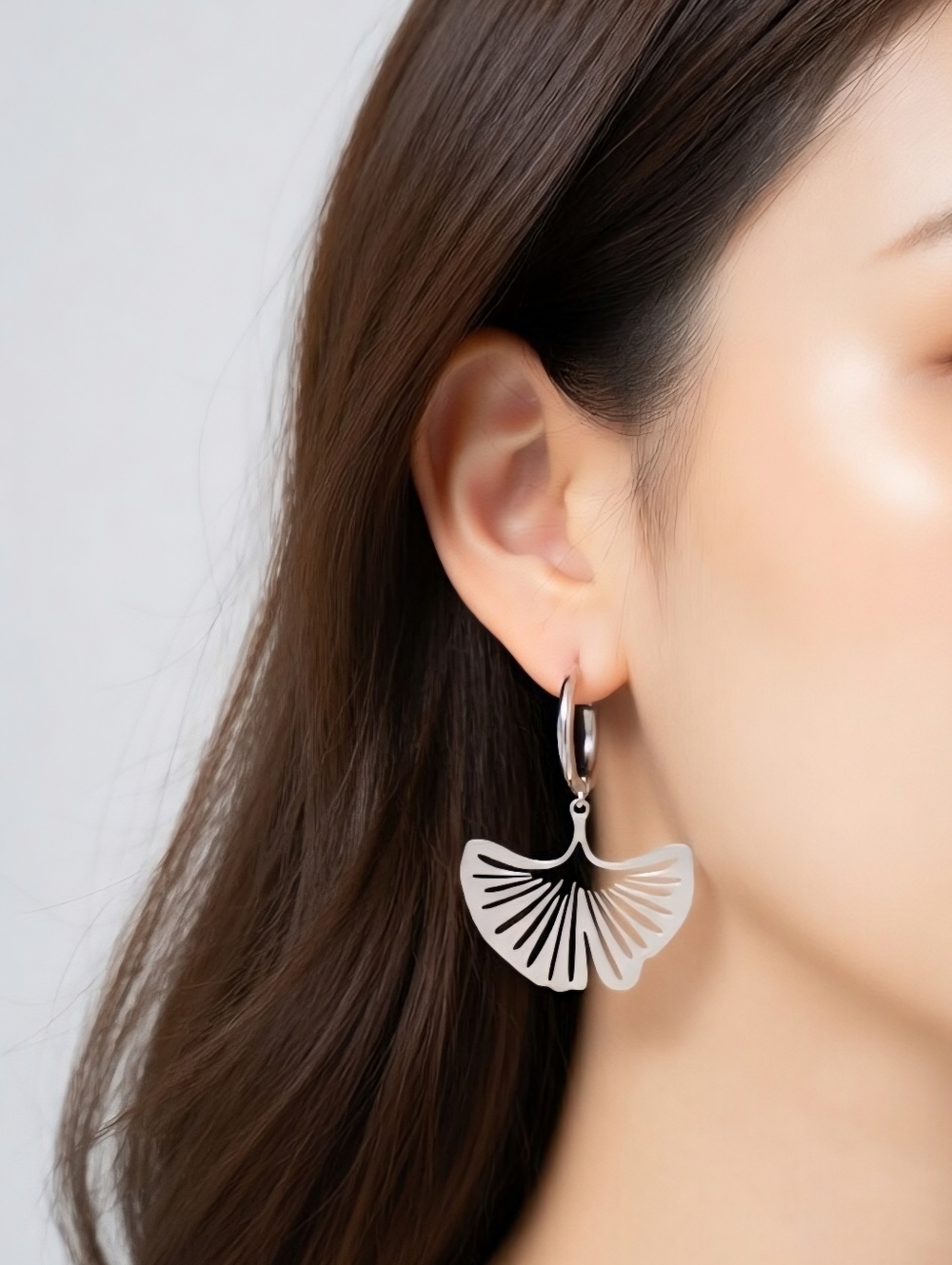 Elegant stainless steel earrings with a dangling ginkgo leaf.